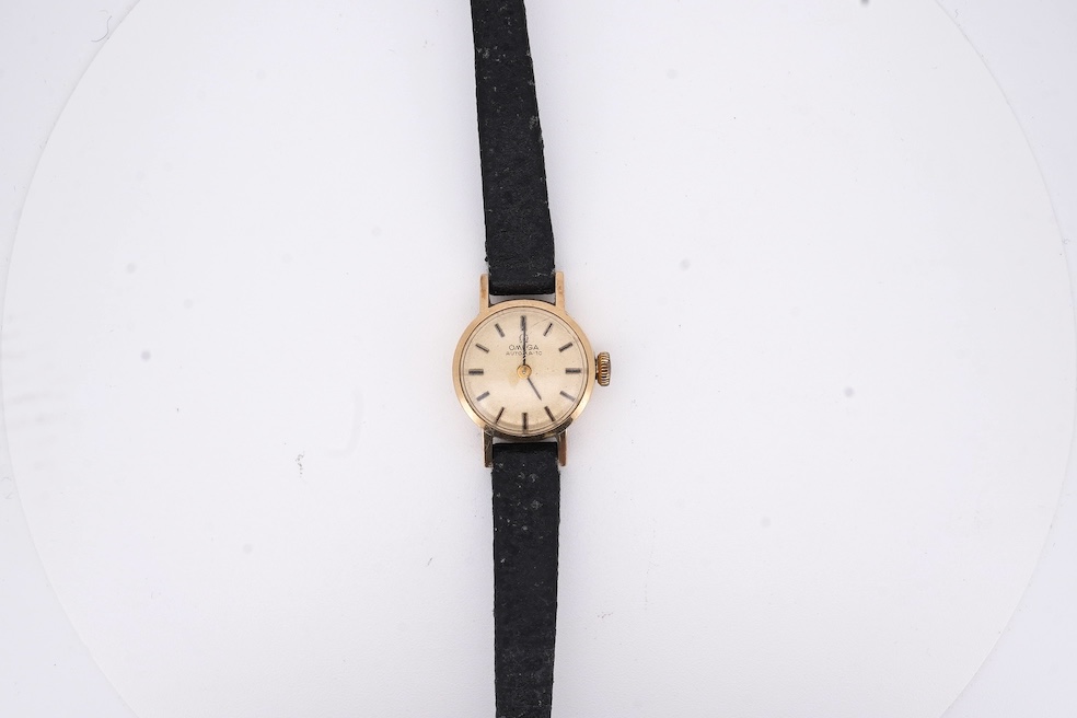 A lady's 9ct gold Omega Automatic wrist watch, on an associated leather strap, gross weight 11 grams. Condition - poor to fair